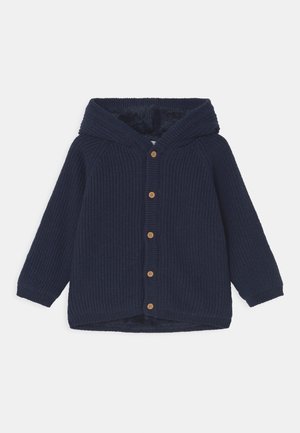 Marineblå hættetrøje med ribbet tekstur, med en knaplukning foran, træknapper og en blød, fuzzy indvendig foring.