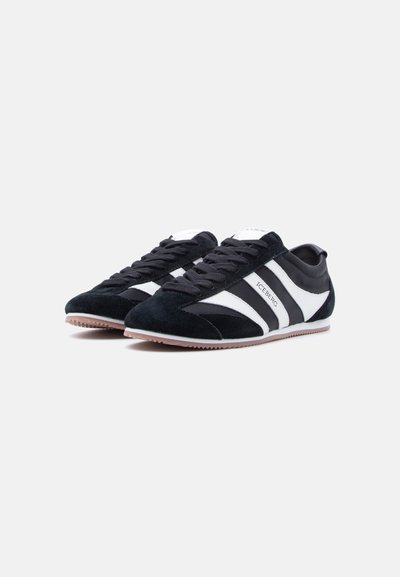 Paire de baskets basses noir et blanc avec des panneaux en daim et en cuir, arborant le logo "ICEBERG" sur les bandes latérales.