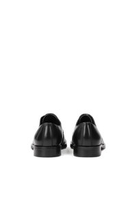 Pantofi din piele neagră cu un finisaj neted, vârf rotunjit și un design minimalist. Talpă complet neagră cu un toc ușor.