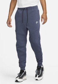 Nike sweatpants i mörkblått, med en elastisk midja och justerbara dragsnören, smalnande ben och diskreta sidofickor.