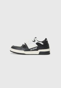 Zwart-witte sneaker met leren bovenwerk, geperforeerde details, textuur zijpaneel en contrasterende rubberen zool met branding.