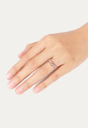 Stapelhülsenset aus rosévergoldetem Metall mit geflochtenem Muster und einem kleinen klaren Edelsteinakzent. Mittlere Breite und glatte Oberfläche.