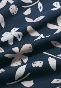 Tengerészkék szövet virágmintával krémszínű tónusokban, absztrakt levél- és szirmalakzatokkal, amelyek texturált megjelenést kölcsönöznek.
