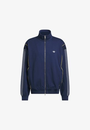 Chaqueta deportiva azul marino con cremallera, hecha de tejido suave, con detalles amarillos y rayas grises en las mangas; pequeño logo en el pecho.