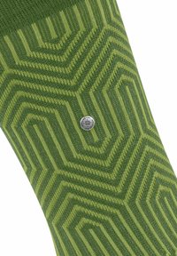 Zielona skarpetka w wzory z geometrycznym motywem w różnych odcieniach zieleni, z małym metalicznym detalem logo. Włókno o teksturze dzianiny w całej skarpetce.