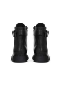 Black leather ankle boots featuring a smooth texture, zip closures, and decorative straps at the ankle, with a sturdy rubber sole.