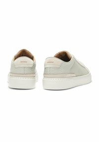 Sneakers grigio chiaro con una tomaia testurizzata, dettagli in suede e suola in gomma bianca. Presentano un design minimalista e un branding sobrio.