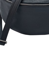 Ronde zwarte leren crossbody tas met een gestructureerde afwerking, zilveren rits en verstelbare schouderband. Focus op minimalistisch ontwerp en een gladde oppervlak.