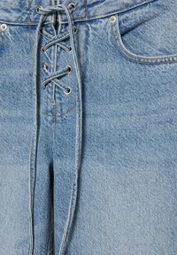 Blugi din denim bleu deschis, cu închidere frontală cu șiret, cusături vizibile, nituri și buzunar frontal pe partea dreaptă.
