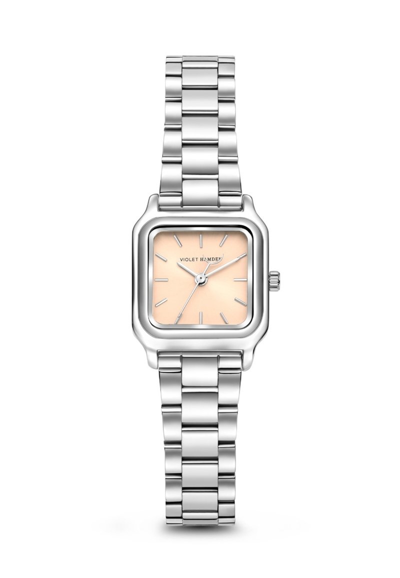 Montre carrée en acier inoxydable argenté avec un cadran pêche et des marqueurs d'heure argentés. Elle est équipée d'un bracelet en métal maillé et d'une couronne sur le côté.