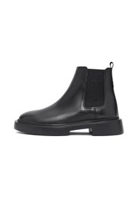 Botas Chelsea negras de cuero con paneles elásticos en los costados y puntera redondeada. Presentan una suela de goma plana y una lengüeta en la parte trasera para ponerlas y quitarlas con facilidad.