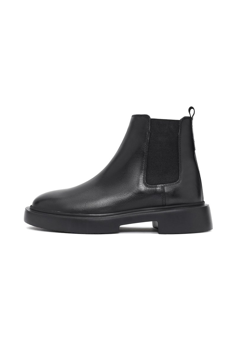 Botas Chelsea negras de cuero con paneles elásticos en los costados y puntera redondeada. Presentan una suela de goma plana y una lengüeta en la parte trasera para ponerlas y quitarlas con facilidad.