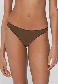 Brązowe bikini dolne o minimalnej pokrywie, z gładkiego materiału, bezszwowym wzornictwem i cienkimi ramiączkami podkreślającymi linię talii.