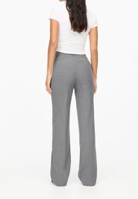 Gray, wide-leg trousers made from a textured fabric, featuring a fitted waist and a clean finish with minimal visible seams.