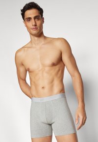 Grå bomullsboxershorts med logo-merket elastisk midjebånd. Fitted design, midt-lår lengde, og glatt tekstur.