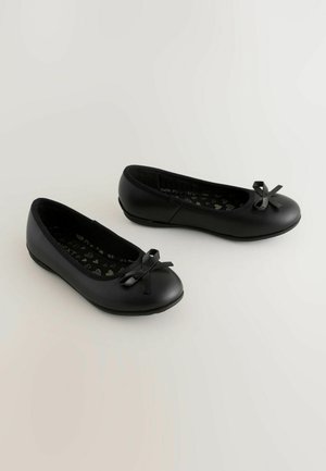 Fekete balettcipők sima külső anyagból, kicsi masni díszítéssel az orrán és szív mintázatú béléssel.