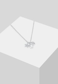 Colier argintii cu o lănțișor delicat, având un stea de mare, o scoică și un pandantiv oval neted. Remarcat pentru farmecul său inspirat de ocean.