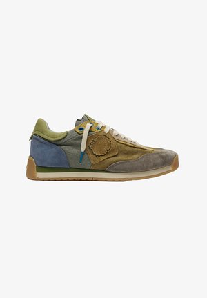 Zapatilla deportiva de corte bajo en tonos verdes, marrones y azules con cordones beige y suela texturizada, mostrada de lado sobre un fondo blanco.