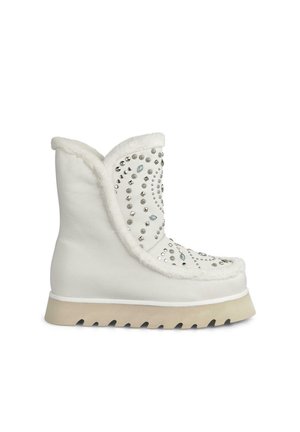 Weiße Knöchelstiefel mit strukturiertem Finish, ausgestattet mit metallischen Nieten und Edelsteinen. Weiche Fellakzente am Kragen und eine beige Gummisohle.