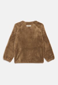 Καφέ φλις μπλούζα μακρύ μανίκι με στρογγυλή λαιμόκοψη, ελαστικούς καρπούς και μια μικρή ετικέτα κοντά στον λαιμό στο πίσω μέρος.