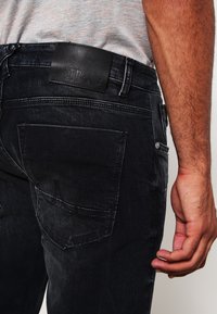 Svarta denimjeans med en läderetikett från LTB, med en klassisk femfickdesign och en något avbleknad yta.