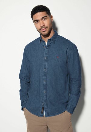 Denim button-up shirt in dark blue, featuring a front placket, long sleeves, single chest pocket, and a small red logo accent.