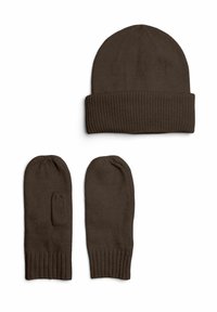 Gorro de punto marrón con puño doblado, combinado con manoplas a juego marrones. Todas las piezas presentan una textura acanalada y una forma estilizada.
