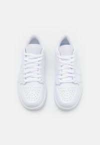 Weiße Sneaker mit glattem Lederfinish, flachen Schnürsenkeln, gelochtem Zehenbereich für Atmungsaktivität und geprägt eingraviertem Logo an der Seite und Zunge.