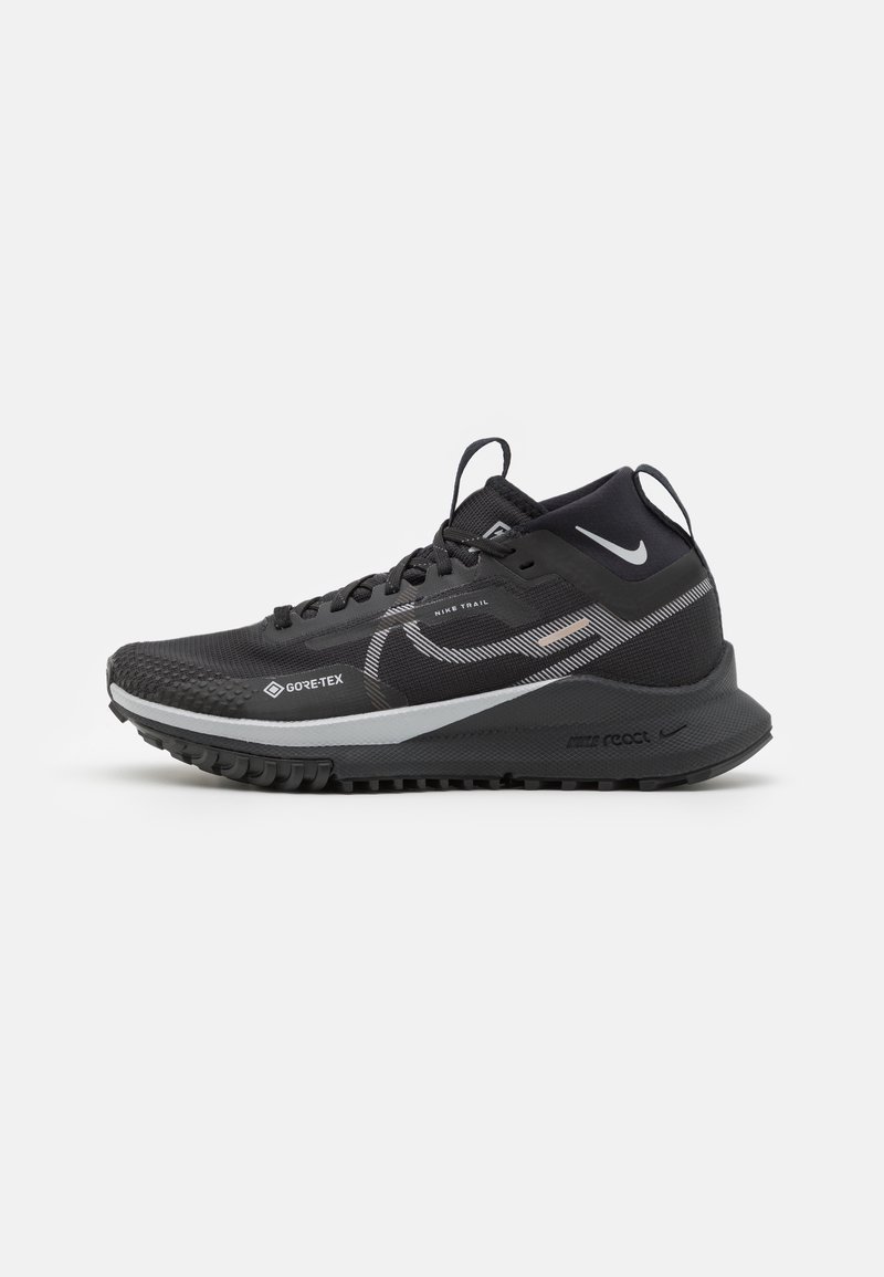 Zwarte trailrunning schoenen met een gestructureerde bovenkant, Gore-Tex branding, reflecterende accenten, een gevoerde tussenzool en een robuuste buitenzool voor grip.