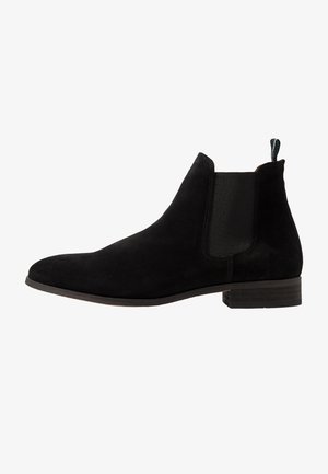 Schwarze Wildleder Chelsea-Boots mit elastischen Seitenpanelen, abgerundeter Zehenpartie und niedrigem, gestapeltem Absatz. Verfügt über eine Zugschlaufe für ein einfaches Anziehen.