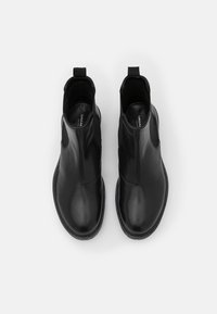 Bottines en cuir noir avec un design élégant, comprenant des panneaux latéraux élastiques, des languettes de traction et une texture lisse et brillante.