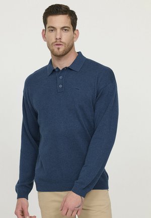 Pull-over tricoté bleu marine avec col polo, trois boutons, manches longues, poignets côtelés et détail texturé. Petit logo sur la poitrine.