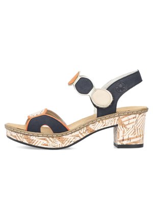 Sandale à talons noire et orange avec une plateforme en liège beige texturé. Présente des accents circulaires et un design de soutien au niveau du talon.