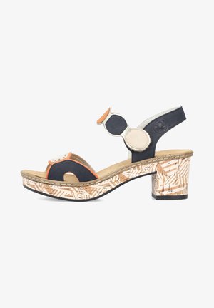 Sandale à talons noire et orange avec une plateforme en liège beige texturé. Présente des accents circulaires et un design de soutien au niveau du talon.