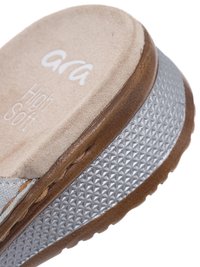 Primer plano de la suela de una sandalia de cuña alta en tonos marrón suave y plateado, con textura antideslizante y detalles de costura.