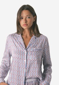 Ubranie nocne w geometryczny wzór w odcieniach niebieskiego i burgundowego, wykonane z miękkiego materiału, z koszulą zapinaną na guziki i kieszonką.