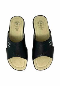 Le ciabatte in pelle nera presentano un design a fascia incrociata, una soletta in tan strutturata e un piccolo dettaglio decorativo sul lato. Fatto in Italia.