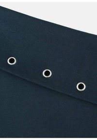 Tessuto blu navy con una superficie liscia, dotato di tre occhielli metallici lungo il bordo, progettato per infilare lacci o cinturini.