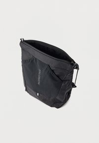 Μαύρη θήκη Salomon με ανοιχτό φερμουάρ, λοξή όψη σε λευκό φόντο.