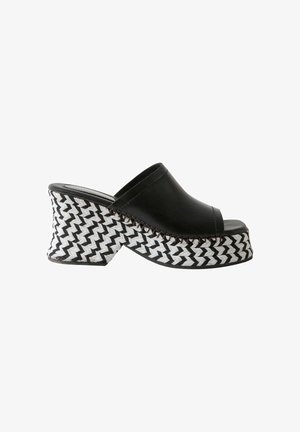 Mule noire à bout ouvert avec un talon plateforme tissé noir et blanc épais et un design à enfiler.