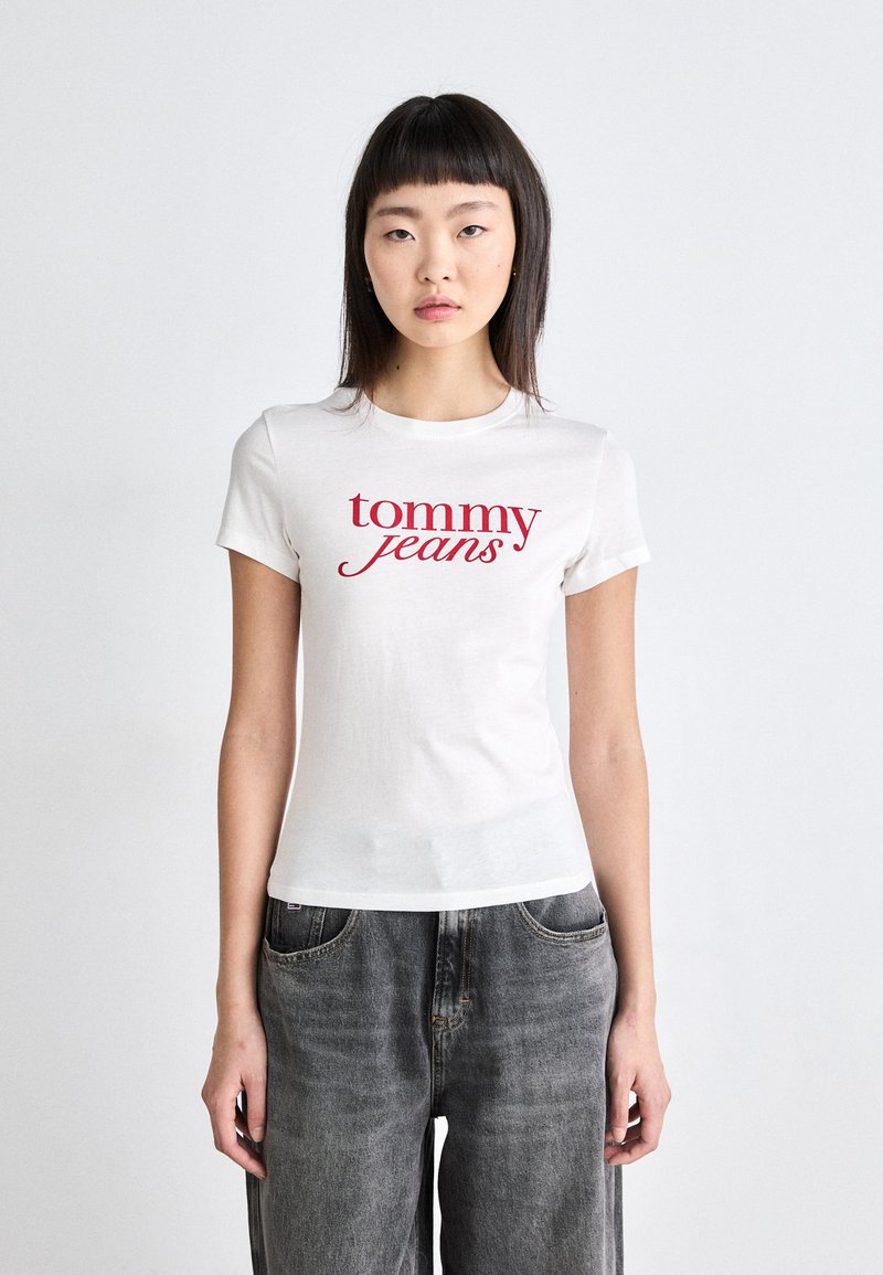 T-shirt bianca a maniche corte con la scritta rossa "tommy jeans" stampata sul petto, realizzata in cotone, con una vestibilità classica e collo a giro.