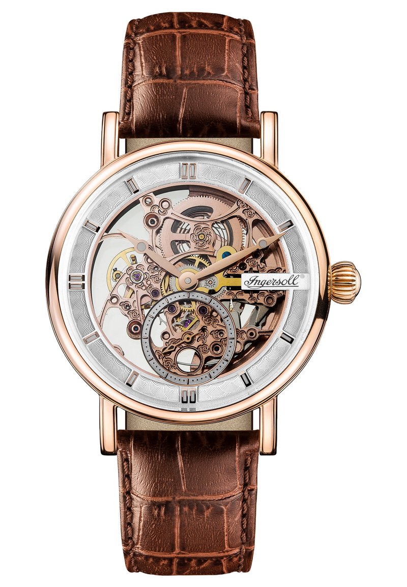 Orologio in tonalità oro rosa con quadrante scheletrato trasparente, cinturino in pelle con motivo coccodrillo marrone e indici delle ore con accenti argentati.