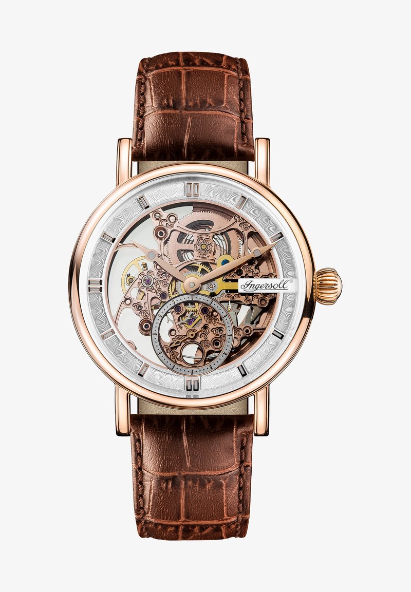 Orologio in tonalità oro rosa con quadrante scheletrato trasparente, cinturino in pelle con motivo coccodrillo marrone e indici delle ore con accenti argentati.