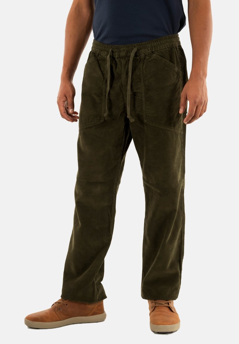Pantaloni in corduroy verde oliva con vita regolabile, dotati di due tasche frontali e una vestibilità comoda, abbinati a scarpe marroni chiare.
