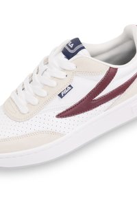 Sneaker bianche e beige con dettagli perforati, accenti bordeaux e un logo blu. Dotate di una suola ammortizzata e un design di allacciatura standard.