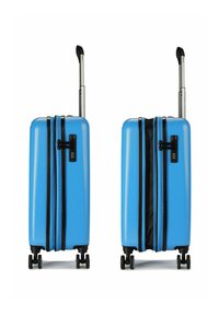 Blauwe harde koffer met zwarte ritsen, een combinatie slot en een uitschuifbaar handvat. Vier wielen voor mobiliteit; structuurvlak.