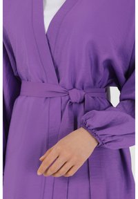Purple waist-length robe with a tie belt. Features a V-neck, gathered sleeves, and a lightweight, textured fabric.