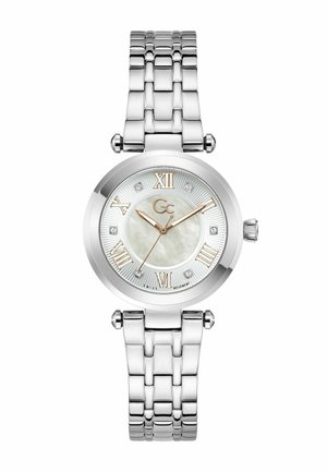 Hõbedast metallist käekell ümmarguse valge pärlmutterkettaga, kuldsed rooma numbrid, teemantkristallid tunde tähistamas ja kolm kuldset osutajat näitamas aega 10:10:37.