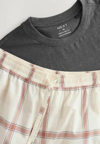 Mörkgrå T-shirt med rund hals som matchas med ljusa rutig shorts med elastisk midja och dragsko, i bruna och krämfärgade ränder.