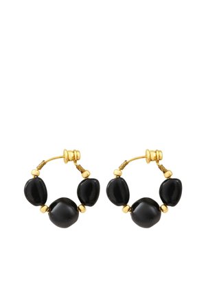 Boucles d’oreilles créoles en or avec trois grosses perles noires irrégulières espacées uniformément le long de chaque créole.